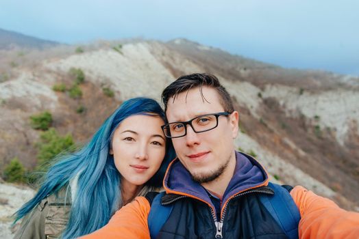 Hiker young couple doing selfie in the mountains outdoor