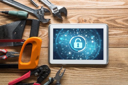 Tablet pc with security concept on screen and industrial tools around