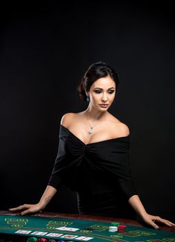 sexy woman with poker cards and chips. Female player in a beautiful black dress