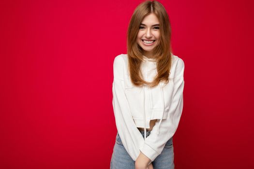 Photo of beautiful positive smiling adult woman wearing stylish clothes standing isolated on colorful background with copy space looking at camera.