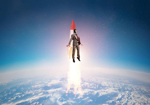 Business person in aviator hat flying on rocket. Progress and innovation technology. Corporate businessman flying with jetpack rocket in blue sky above clouds. Leadership motivation concept.