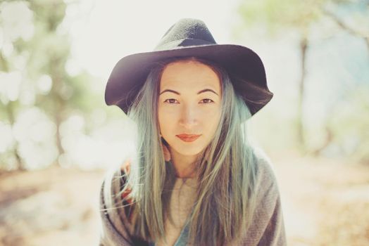 Fashionable young woman wearing in hat walking in summer forest outdoor, smiling woman looking at camera
