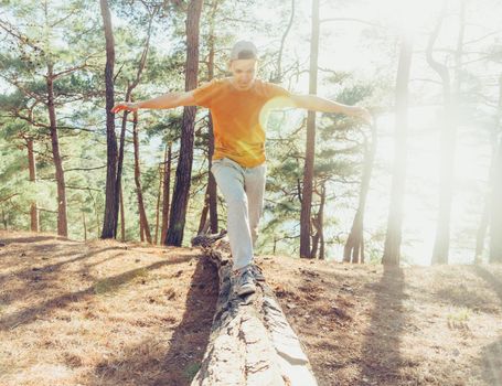 Happy guy walking in summer pine forest outdoor at sunny day. Concept of healthy lifestyle