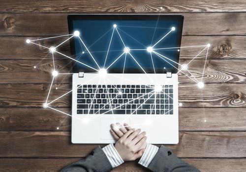 Top view of laptop on wooden surface and businesswoman hands