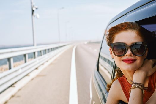 pretty woman in sunglasses rides in a travel car. High quality photo