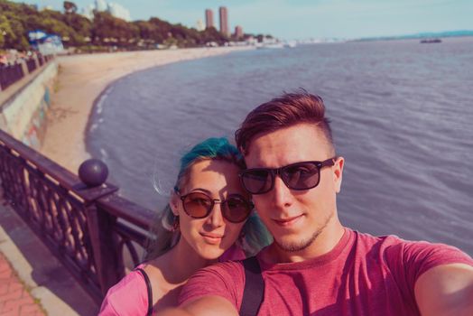 Traveler young loving couple doing self-portrait on background of coastline in city