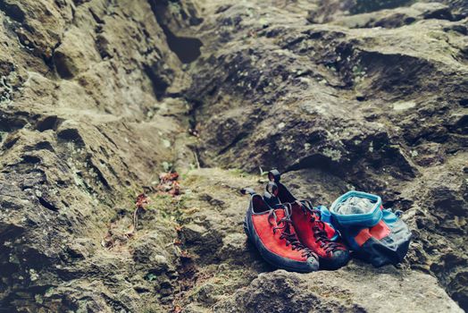 Climbing shoes and chalk bag with magnesium powder on stone rock outdoor