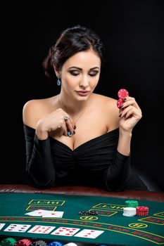 sexy woman with poker cards and chips. Female player in a beautiful black dress