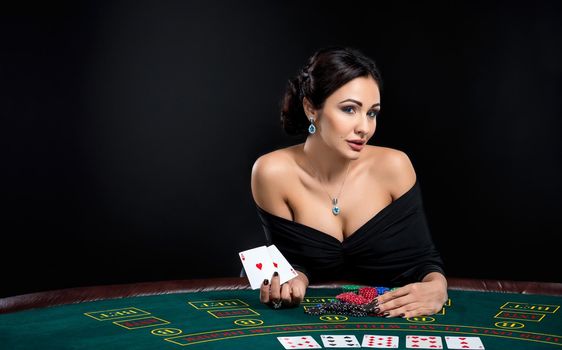 sexy woman with poker cards and chips. Female player in a beautiful black dress