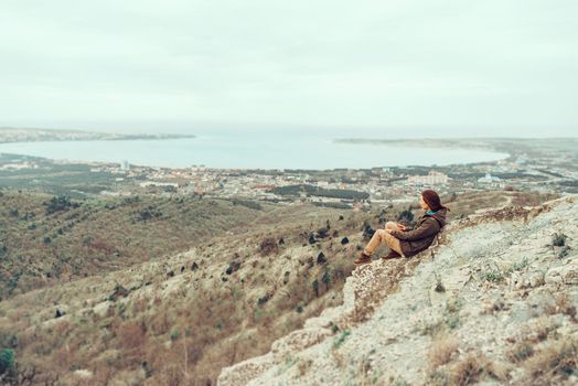 Hiker young woman resting in the mountains over the bay sea outdoor