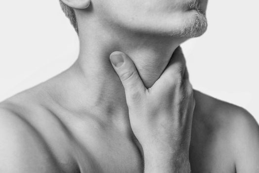 Man touches the throat, sore throat. Monochrome image, isolated on a white background