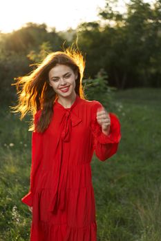 woman in red dress posing nature sun fun. High quality photo