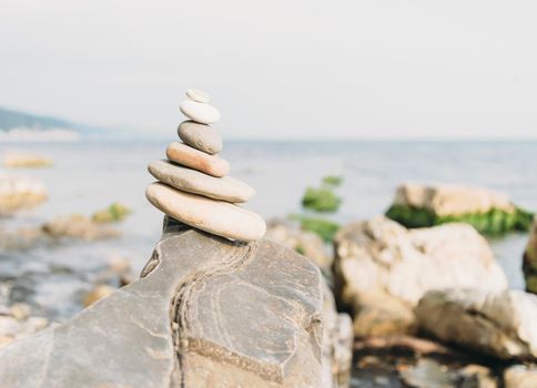 Stones pyramid on coast on background of sea