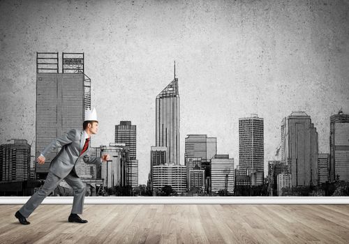 Young handsome businessman wearing white paper crown running in a hurry
