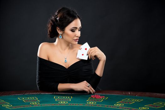 sexy woman with poker cards and chips. Female player in a beautiful black dress
