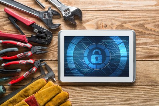Tablet pc with security concept on screen and industrial tools around