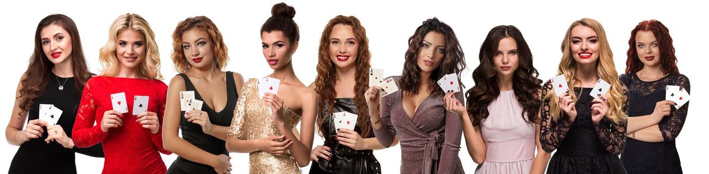 Beautiful women with bright make-up and stylish hairstyles, in colorful dresses and jewelry. They showing playing cards while posing isolated on white background. Gambling, poker, casino. Close-up