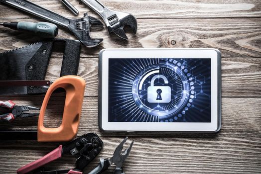 Tablet pc with security concept on screen and industrial tools around