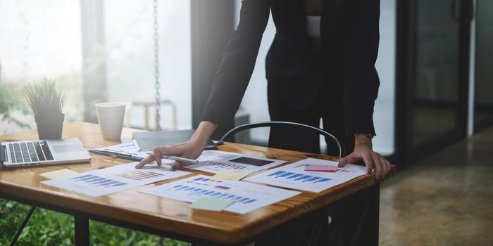 Close up Hand of Business woman working to analyze technical price graph and indicator.