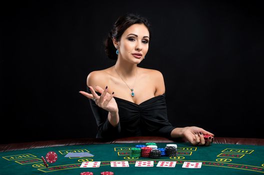 sexy woman with poker cards and chips. Female player in a beautiful black dress