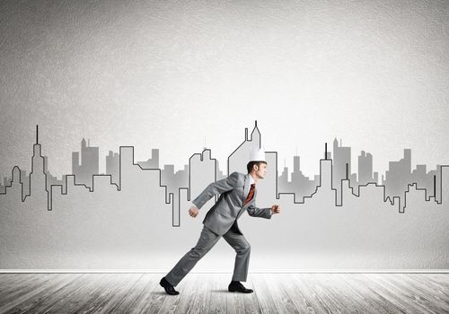 Young handsome businessman wearing white paper crown running in a hurry