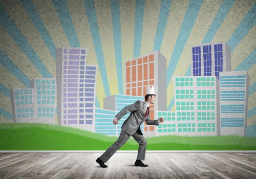 Young handsome businessman wearing white paper crown running in a hurry