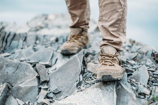 Hiker woman walking on rocks outdoor, view of legs