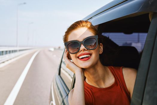 pretty woman in sunglasses rides in a travel car. High quality photo