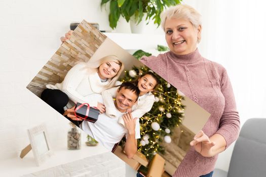 woman holding a photo canvas with a picture of christmas.