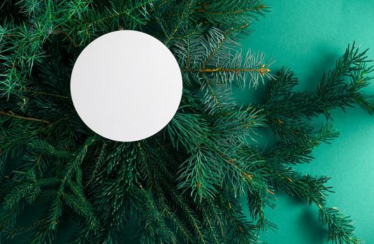 Christmas green background. Pine branches, needles and Christmas trees. View from above. Round frame with place for text. Christmas nature background. December mood concept. Copy space.