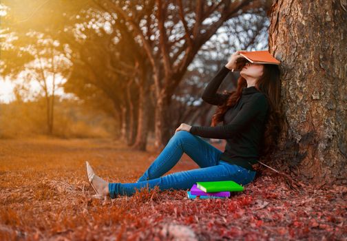 young woman in stress situation when reading a book in the park