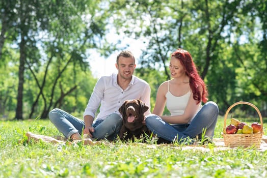 A couple and their dog in the park. Spending time with friends