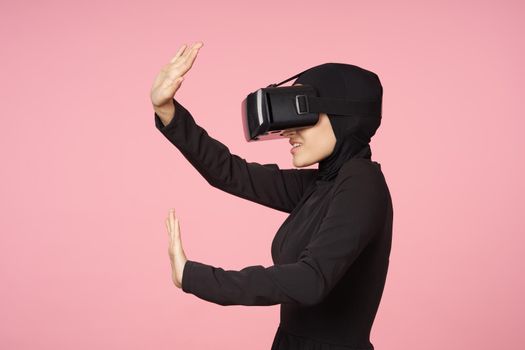 woman in black hijab glasses virtual reality technology movie watching. High quality photo