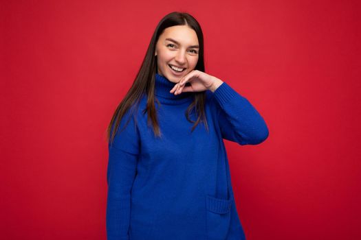 Photo of beautiful positive smiling adult woman wearing stylish clothes standing isolated on colorful background with copy space looking at camera.