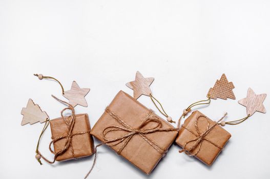 Christmas Composition with Craft Gift Boxes, Branches Fir Tree, and Decorations on Light Background. Flat Lay