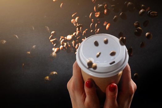 Photo of a paper coffee cup with a mixture of arabica and robusta beans in the background