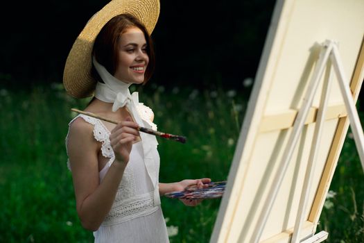 Woman in white dress artist easel painting nature landscape. High quality photo