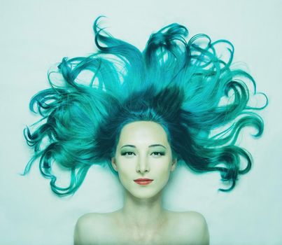 Beautiful young woman with hair of turquoise color looking at camera, top view. Image of seamaid