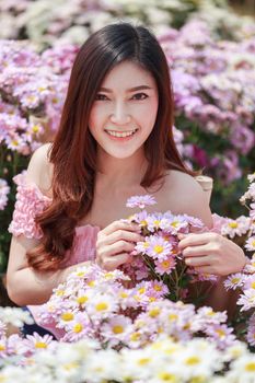 beautiful woman in colorful chrysanthemum glower garden 