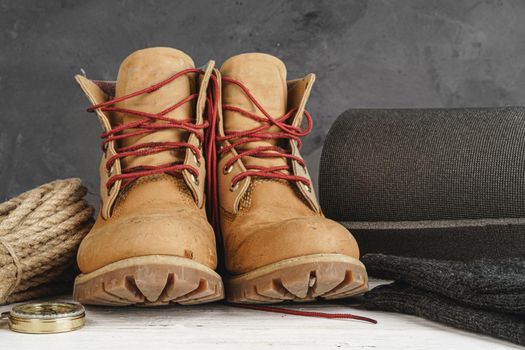 Hiking boots and rope hank on wooden board close up