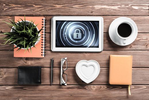 Business workplace with office stuff and tablet with padlock icons on screen