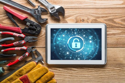 Tablet pc with security concept on screen and industrial tools around
