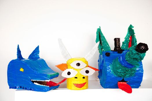 Colorful artistic heads of fantastic animals made with carton and tape composed in set.