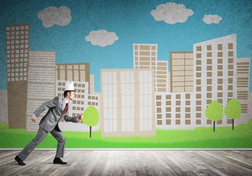 Young handsome businessman wearing white paper crown running in a hurry