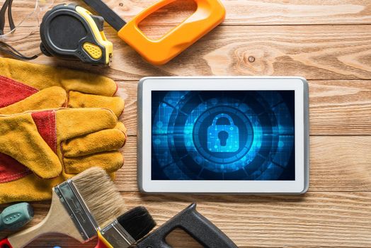 Tablet pc with security concept on screen and industrial tools around