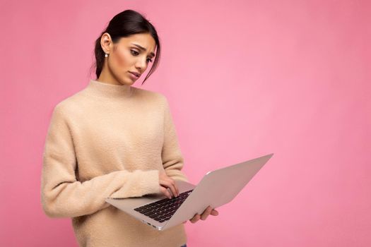 side profile photo of charming pretty sad young lady holding laptop isolated over wall background looking down at netbook.