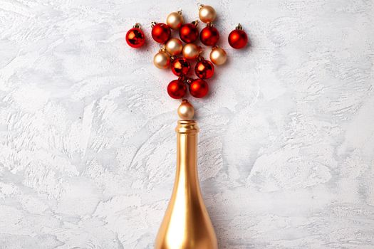 Flat lay composition with gold champagne bottle and Christmas balls top view
