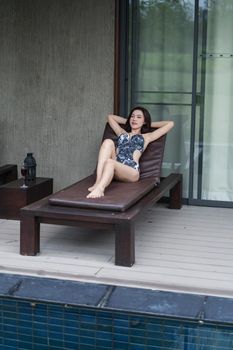 young woman relaxing on a chair at swimming pool