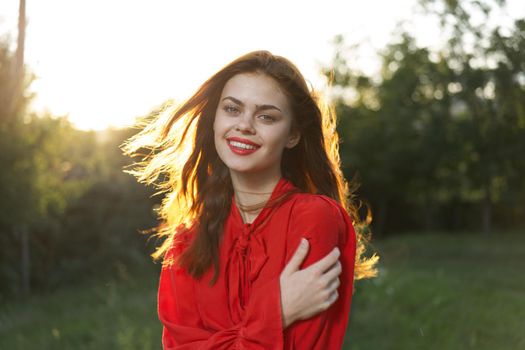 cheerful woman in a red dress in a field outdoors fresh air. High quality photo