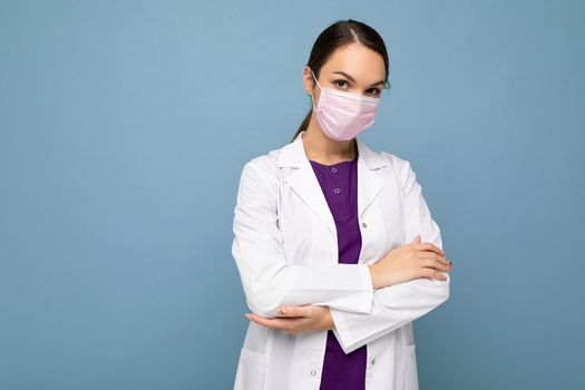 Young woman wearing an anti virus protection mask to prevent others from corona COVID-19 and SARS cov 2 infection isolated over blue background.
